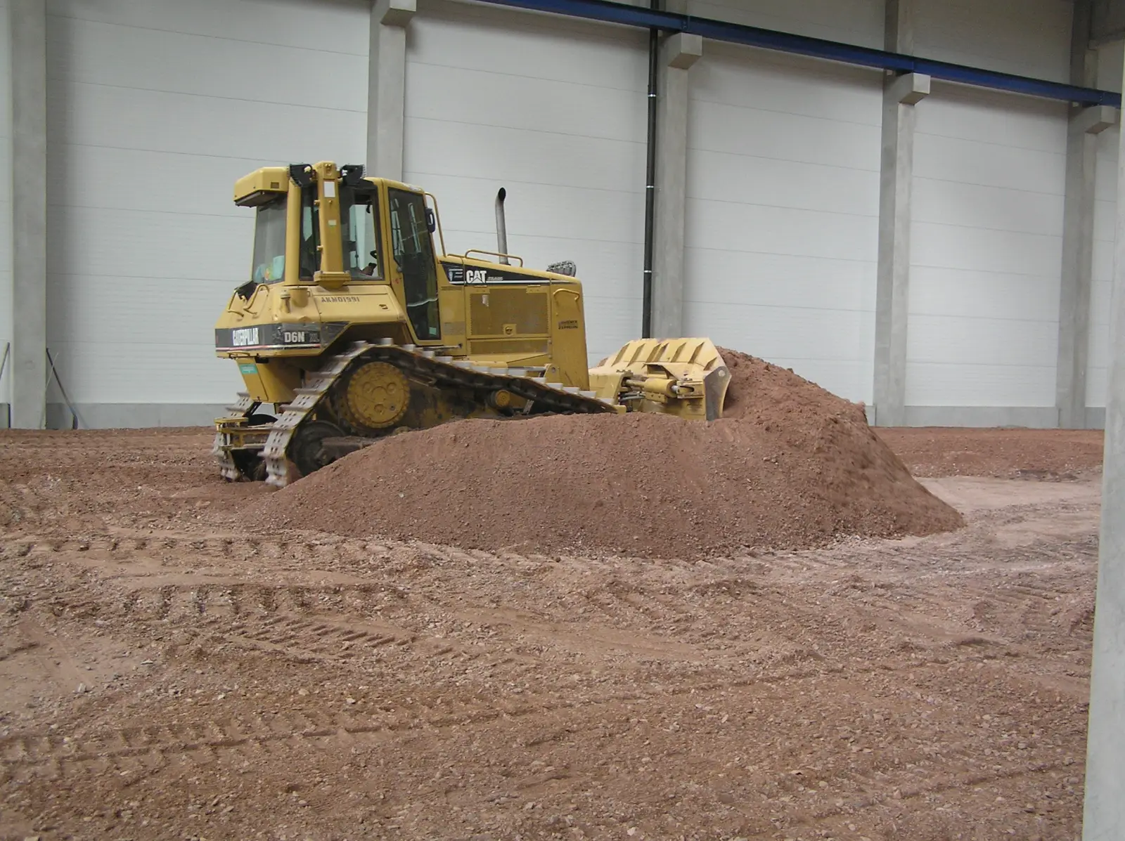 rozhrnování materiálu v již postavené hale